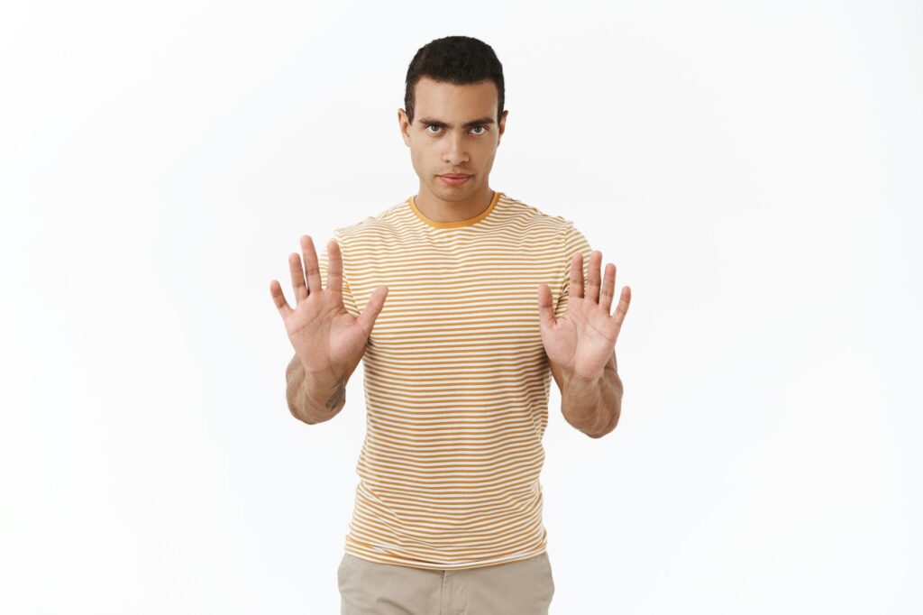 No, I dont want. Serious-looking confident and determined hispanic young masculine man making stop